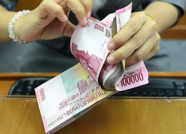 Một nhân viên đếm tiền giấy rupiah của Indonesia. (Nguồn: thestar)